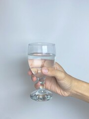 isolated man's hand carrying a glass of mineral water