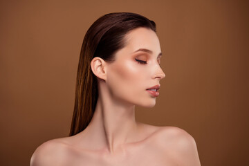 Photo of adorable seductive lady naked shoulders applying maquillage isolated brown color background