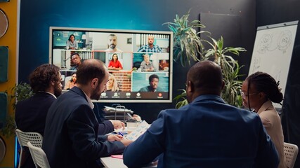 Business associates meeting with stakeholders on a videocall connection, sharing insight and...