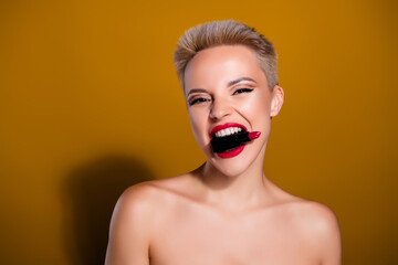 Photo of woman hold red lipstick bite teeth look isolated over yellow mustard color background