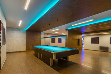 An open space of a private house with an original design of walls and ceiling. A large .billiard...