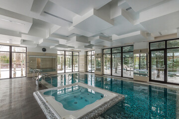 A magnificent indoor swimming pool in a private house with a Jacuzzi. Panoramic Windows with a...