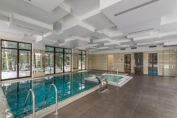 Modern indoor private swimming pool with artificial waterfall, Jacuzzi. Original ceiling .and panoramic windows.