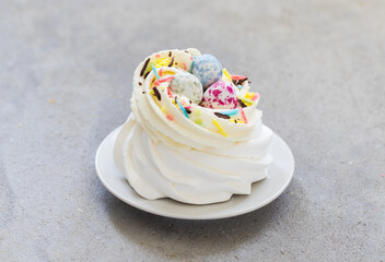 Pavlov's Easter dessert. Meringue with cream cheese. Decorated with chocolates in the shape of...