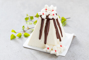 Cottage cheese desser Easter with chocolate. Decorated with white marshmallow flowers. With birch twigs. Close-up