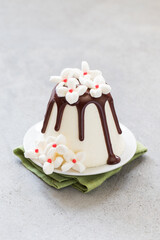 Easter. Ricotta cream dessert with chocolate. Decorated with white marshmallow flowers. On a plate.  On a linen napkin. Close-up