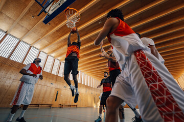 Low angle view of a young african male basketball player dunking the ball