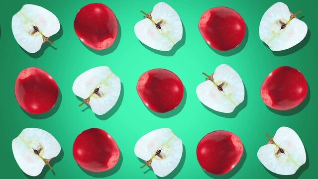 Red apples and white apple slices on a solid green background, with a symmetrical arrangement shown from a top view