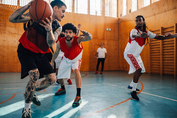 Arabic and hispanic basketball teammates playing together in a sports hall