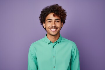 A man with a green shirt and curly hair is smiling