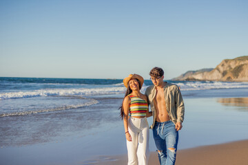 copyspace Multicultural Latina Couple Walking and Smiling on Beach Shore at Sunset