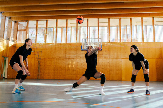 Portrait of a diverse young female volleyball players bumping a ball - Powered by Adobe