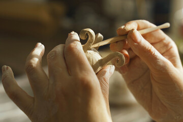 A woman makes a clay product with her hands - a ceramic pot.