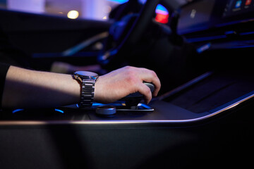 Selector automatic transmission with leather in the interior of a modern expensive car. The background is blurred. Black and brown leather car.