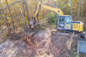 Preparation land for construction of house, uprooted trees using tractor