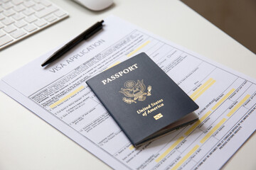 American passport with visa application documents on white table