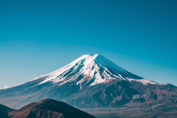 Fototapeta premium A snow-capped mountain peak against a clear blue sky