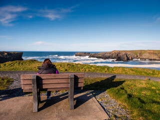 Teenager girl enjoy stunning nature of Kilkee coast and cliff, county Clare, Ireland. Rough...