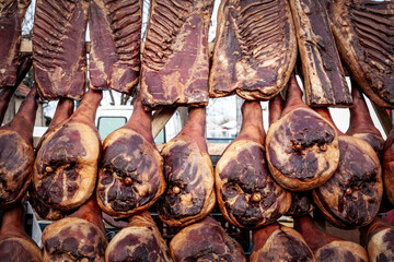 Selective blur on Serbian hams, called prsut, italian style similar to prosciutto crudo, hanging in Serbian countryside. Prosciutto is typical dry cured meat of pork produced in Italy, Spain & Balkans