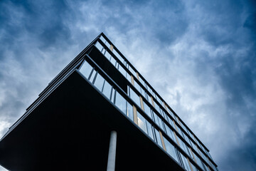 Contemporary German Office Building with Glass Facade Under Cloudy Sky in Urban Business District.