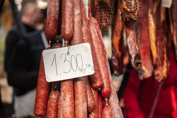 Selective blur on cajna kobasica sausages spiked for sale with a price of 1300 on stand of a...