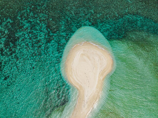 Aerial view of waves in white sandbank with greenish clear water. White Island. Camiguin, Philippines.