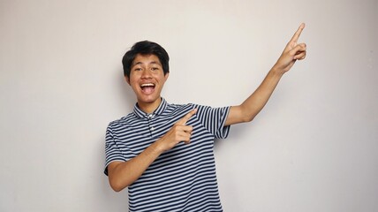 Handsome young Asian man pointing upwards