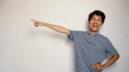 Handsome young Asian man happily pointing to the side