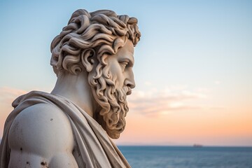 Statue of a classical figure against a scenic sunset backdrop