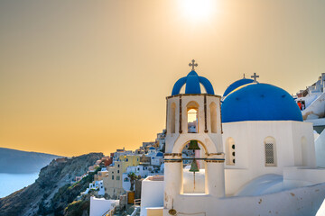 Naklejka premium Blue bell domes of Oia village on Santorini island at sunset. Greece