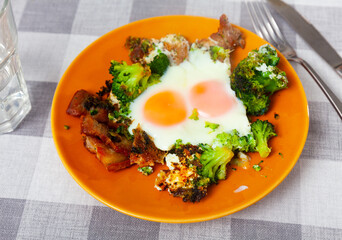 Appetizing breakfast - scrambled eggs with fried lard and broccoli