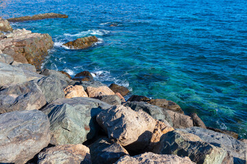  Rocky coast and turquoise water on a sunny day. Rocks on the shore contrasts with the deep blue sea