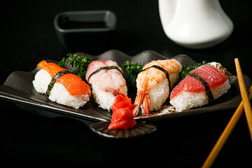 Sashimi sushi set on a black wooden board for sushi on black background. Close up of sashimi sushi...