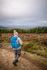 Female hiker in bad irish weather walking in dublin mountains path