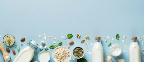 Ingredients for creating different plant-based dairy-free vegan milks and milk bottles on a blue background with space for text.