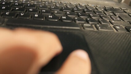 POV: person using a laptop touchpad. Man using a laptop keyboard. Person using a notebook. A QWERTY...