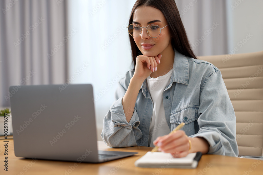 Sticker Young woman watching webinar at table in room