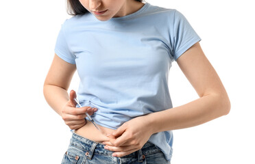 Diabetes. Woman making insulin injection into her belly on white background, closeup