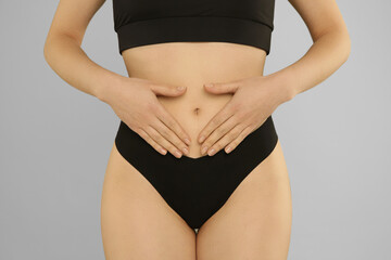 Gynecology. Woman in underwear on grey background, closeup