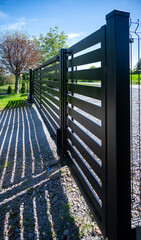 Modern black sliding gate at a residential entrance