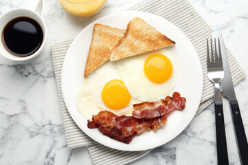 Delicious breakfast with sunny side up eggs served on white marble table, flat lay