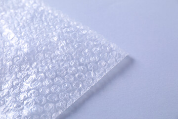 Transparent bubble wrap on gray background, closeup. Space for text