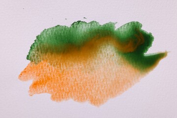 Blot of bright watercolor paints on white paper, top view