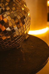 Vintage silver mirrored disco ball on a round table on dark background. Vertical photo party....