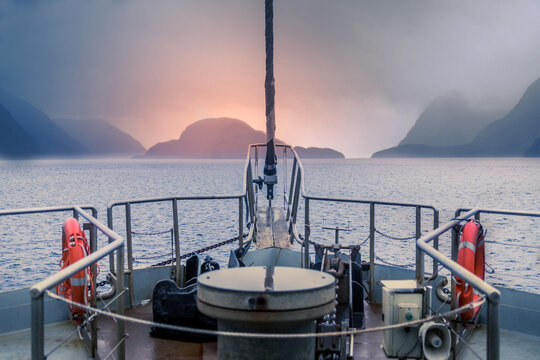 View from the deck of the ship, dawn ower the water in a fjord in cloudy weather, Doubtful Sound Fiord, New Zealand