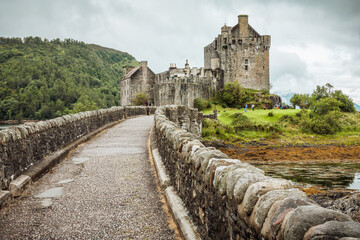 A stone bridge leads to Eilean Donan Castle in Scotland, UK.
