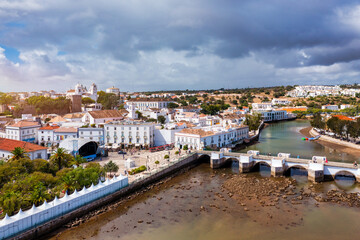 View on historic town of Tavira with Roman bridge over River Gilao, Algarve, Portugal. Cityscape of the Tavira old town with Clock tower, St Marys church, Algarve region, Portugal.