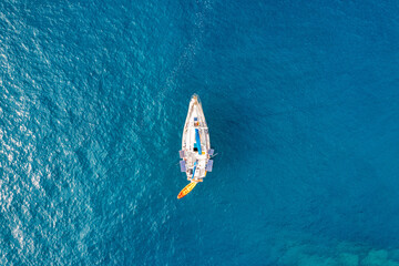 Yacht anchoring in crystal clear turquoise water in front of the tropical island, alternative...