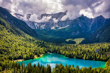 Picturesque lake Lago Fusine in Italy. Fusine lake with Mangart peak on background. Popular travel destination of Julian Alps. Location: Tarvisio comune , Province of Udine, Italy, Europe.