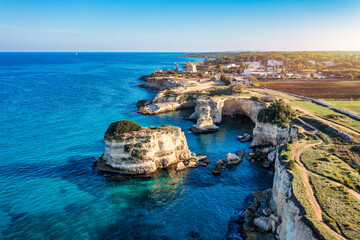 Stunning seascape with cliffs rocky arch and stacks (Faraglioni) at Torre Sant Andrea, Salento...